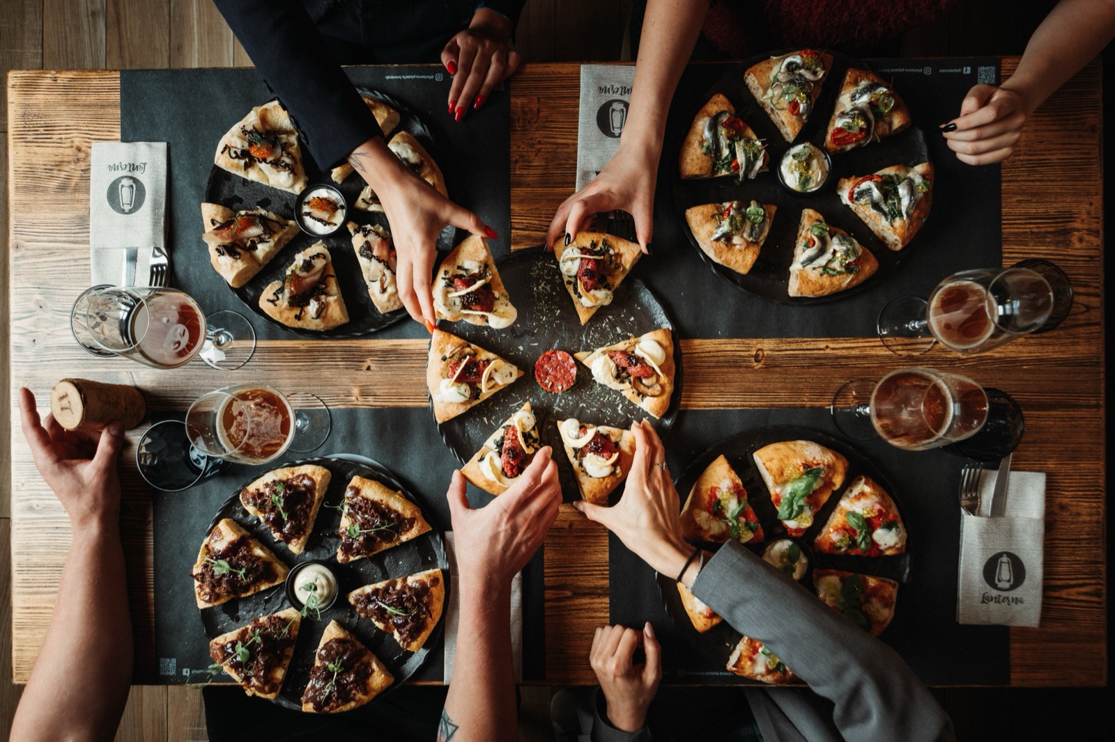 Persone che condividono la pinsa in pizzeria