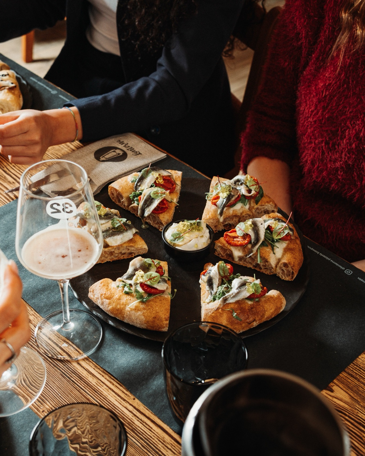 Persone che condividono la pinsa in pizzeria