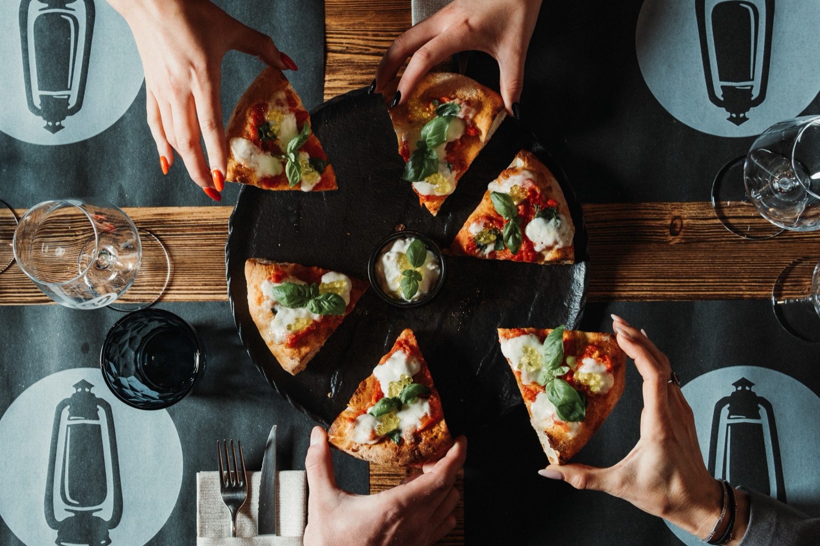 Persone che condividono la pinsa in pizzeria